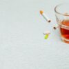 A glass of alcohol and cigarettes in copy space highlights the need for breathalysers for testing other substances.