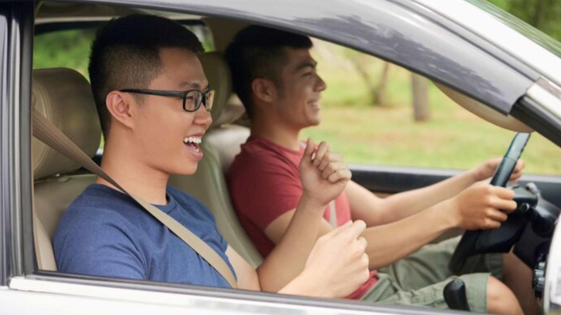 The side view of two men sitting in a car highlights the role of breathalysers for ride-share drivers in ensuring passenger safety.