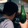 The rear view of a man sitting in a car highlights the importance of international drink-driving laws in ensuring road safety.