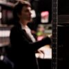 A woman searching through bookshelves for the history of Alcohol Testing Devices.