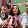 Three friends drinking beer, embodying responsible drinking in universities on a vibrant campus setting.