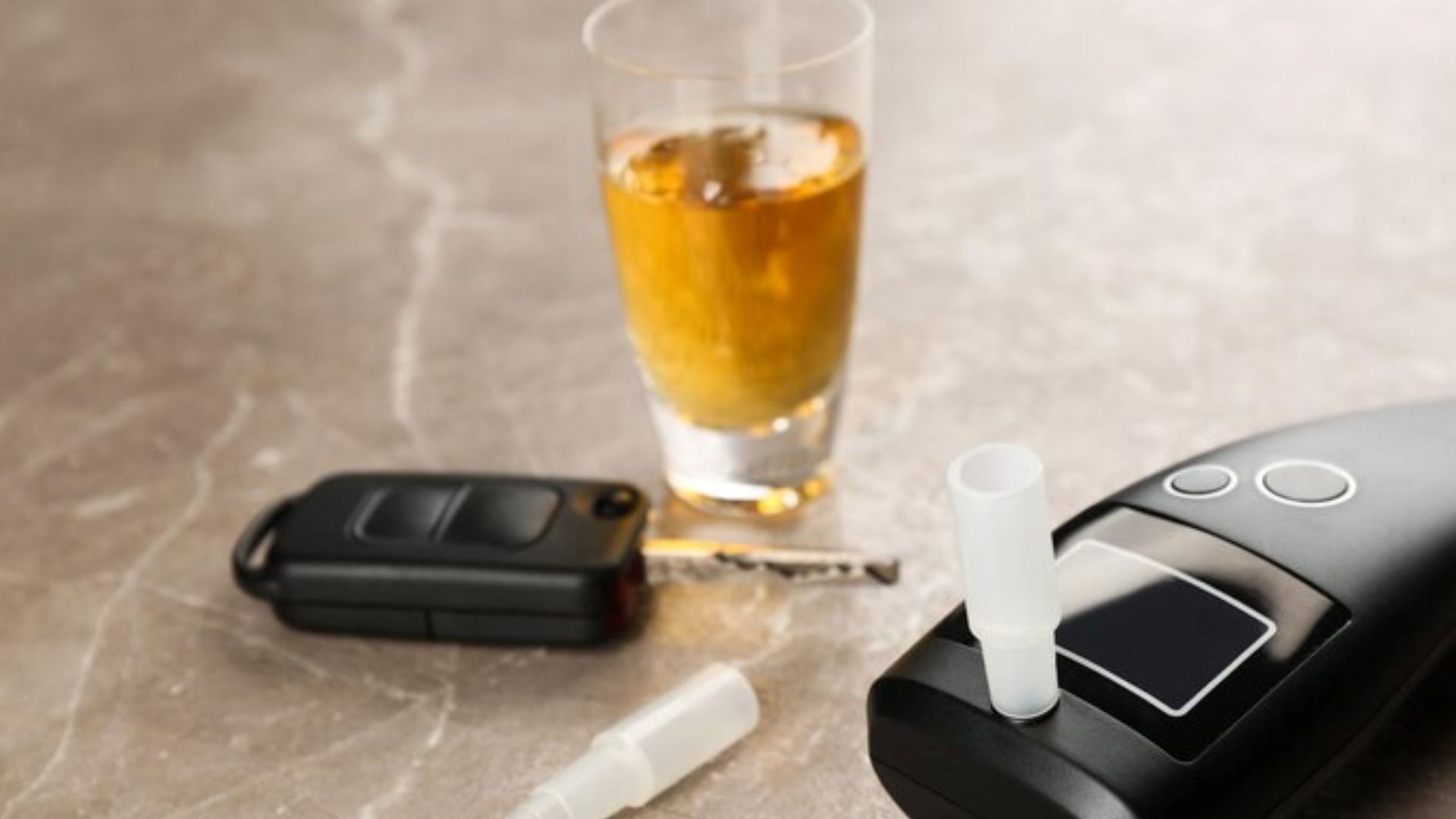 A modern breathalyser rests on a brown marble table, showcasing the design evolution of breathalysers