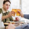 Friends share drinks at a restaurant, reflecting the impact of community-based breathalyser schemes on responsible alcohol consumption.