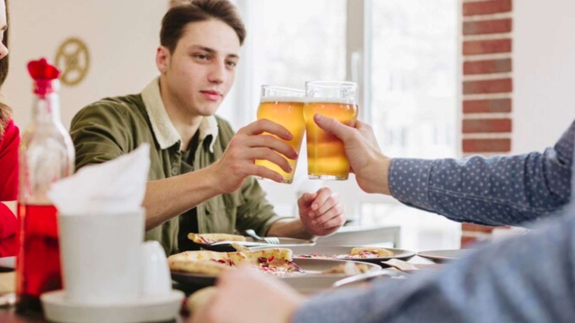 Friends share drinks at a restaurant, reflecting the impact of community-based breathalyser schemes on responsible alcohol consumption.