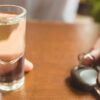 breathalyser standards in australia discussed as man holds car key and shot glass