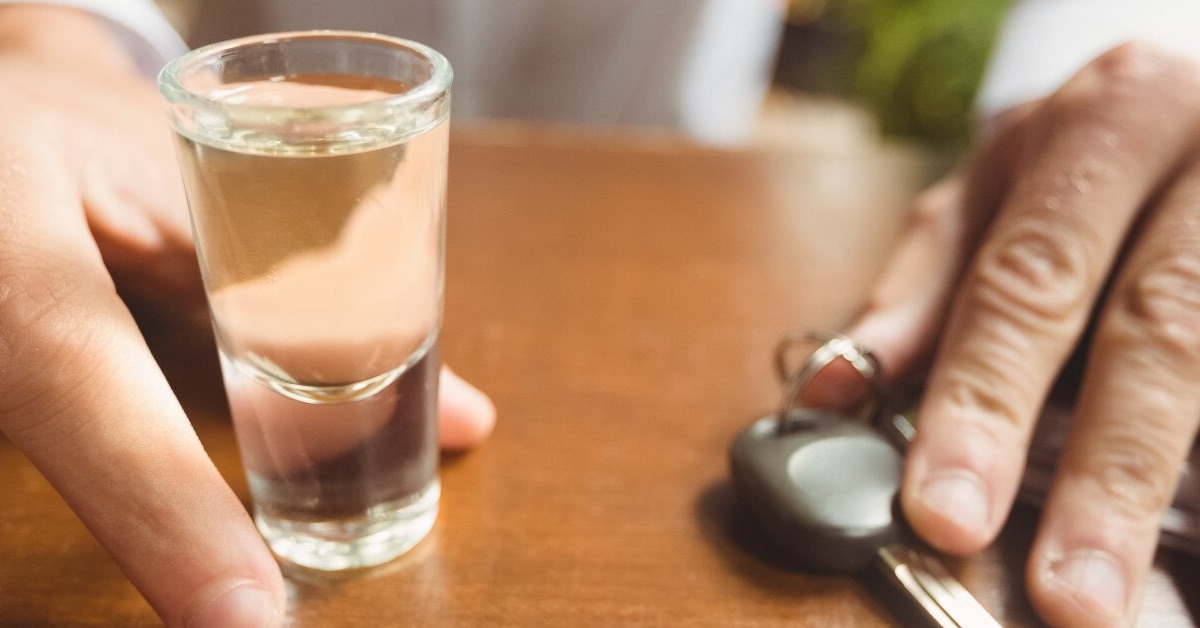 breathalyser standards in australia discussed as man holds car key and shot glass