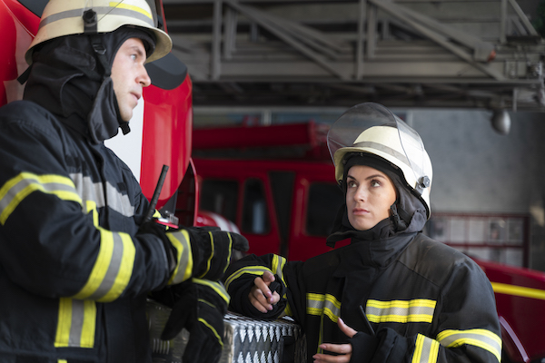 male and female firefighters discuss using breathalysers in emergency services