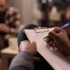 male psychologist takes notes after client uses personal breathalyser