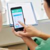 nurse showing patient how to use smartphone-compatible breathalyser